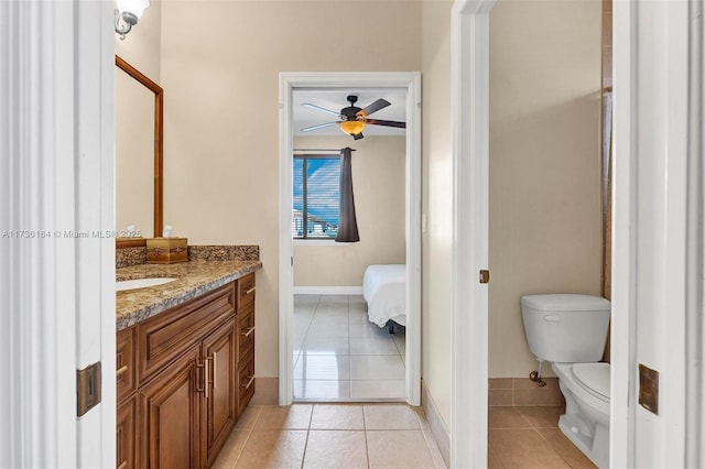 bathroom featuring baseboards, toilet, ceiling fan, tile patterned floors, and vanity