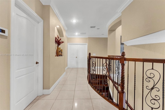 corridor featuring ornamental molding and light tile patterned floors