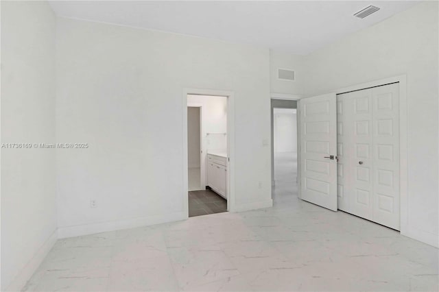 unfurnished bedroom featuring connected bathroom and a closet