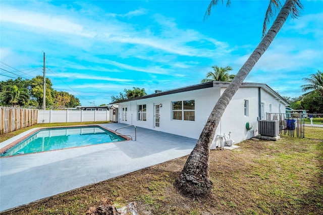 view of pool with a yard, a patio area, and central air condition unit