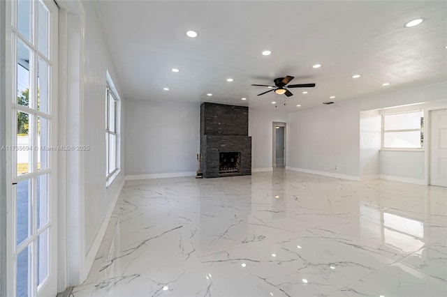 unfurnished living room featuring ceiling fan and a fireplace