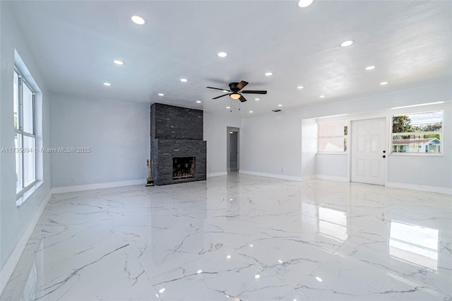 unfurnished living room featuring ceiling fan and a fireplace