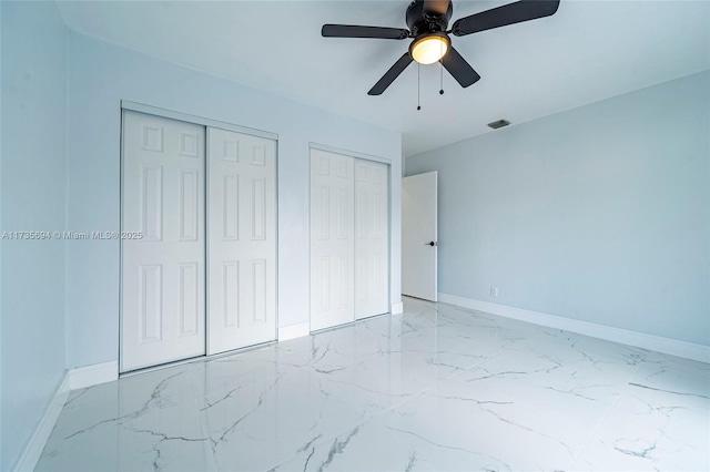 bedroom featuring ceiling fan and multiple closets