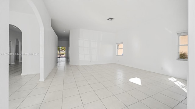 unfurnished room featuring light tile patterned flooring and a healthy amount of sunlight