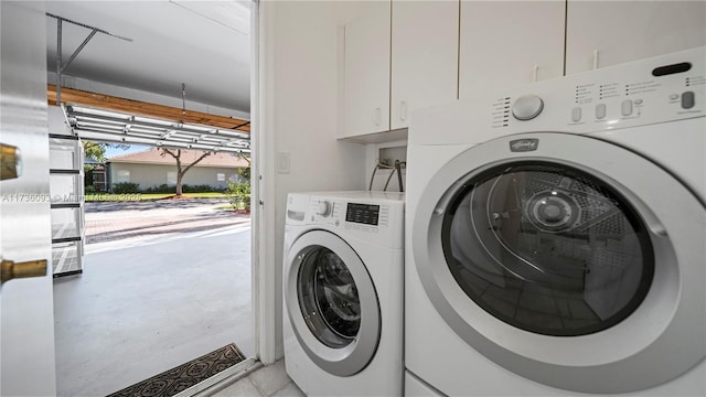 washroom with cabinets and washer and dryer