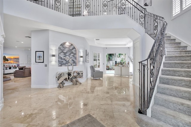 foyer entrance with a raised ceiling and a high ceiling