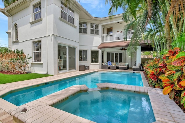 rear view of property featuring ceiling fan, an outdoor hangout area, and a balcony