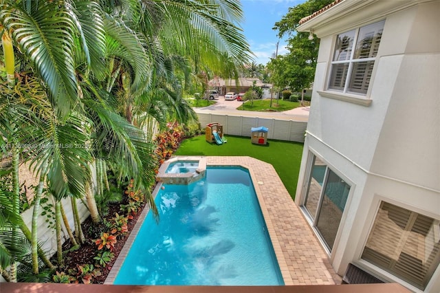 view of swimming pool featuring an in ground hot tub and a lawn