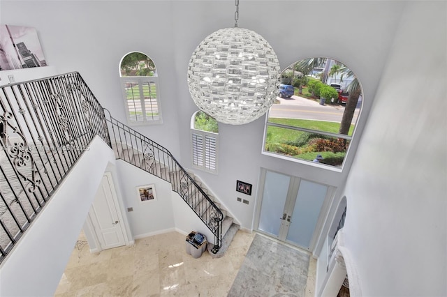 foyer entrance with a towering ceiling and a chandelier