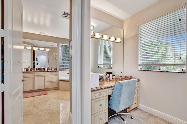 bathroom with a relaxing tiled tub and vanity