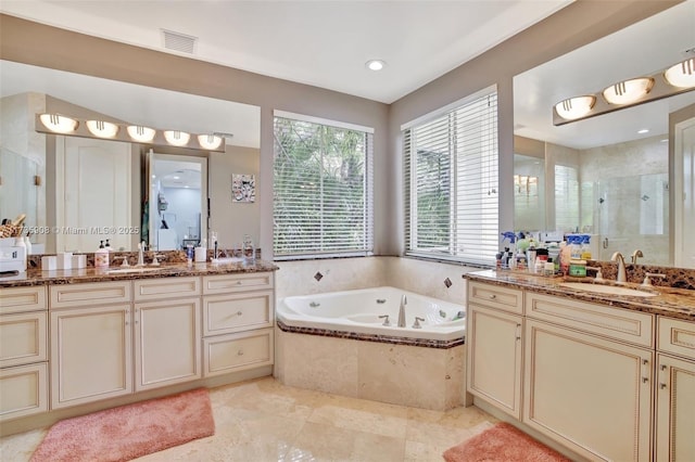 bathroom with vanity and shower with separate bathtub