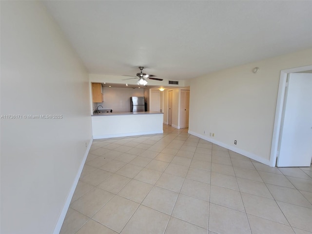 unfurnished living room featuring light tile patterned flooring and ceiling fan