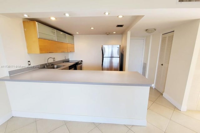 kitchen featuring stainless steel appliances, kitchen peninsula, sink, and light tile patterned floors