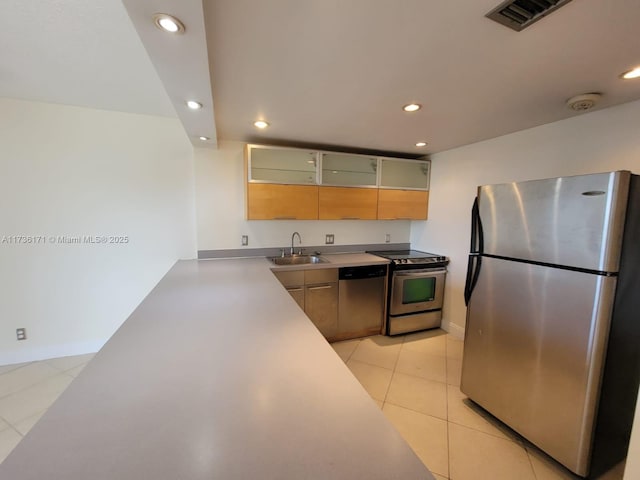 kitchen with light tile patterned flooring, appliances with stainless steel finishes, and sink