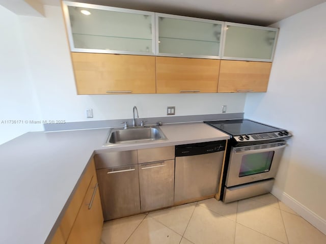 kitchen with light tile patterned flooring, stainless steel appliances, and sink