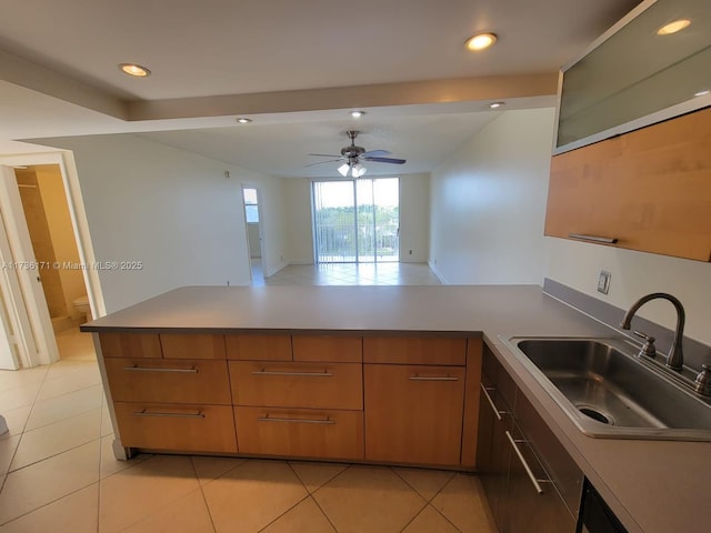 kitchen featuring sink, kitchen peninsula, ceiling fan, and light tile patterned flooring