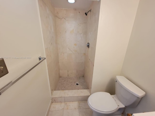 bathroom with tiled shower and toilet