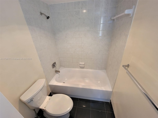 bathroom with tiled shower / bath, toilet, and tile patterned flooring