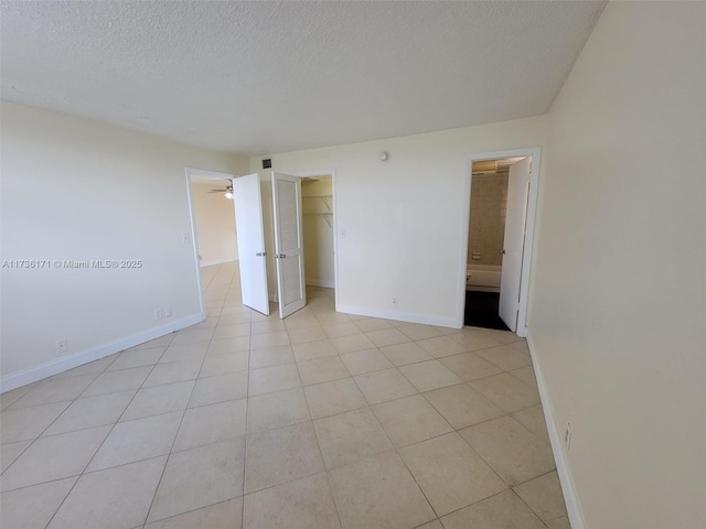 tiled empty room featuring a textured ceiling