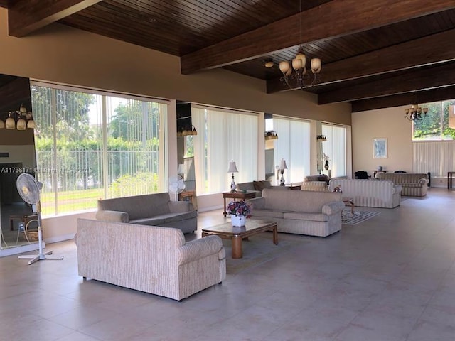 living room featuring beamed ceiling, a healthy amount of sunlight, wooden ceiling, and an inviting chandelier