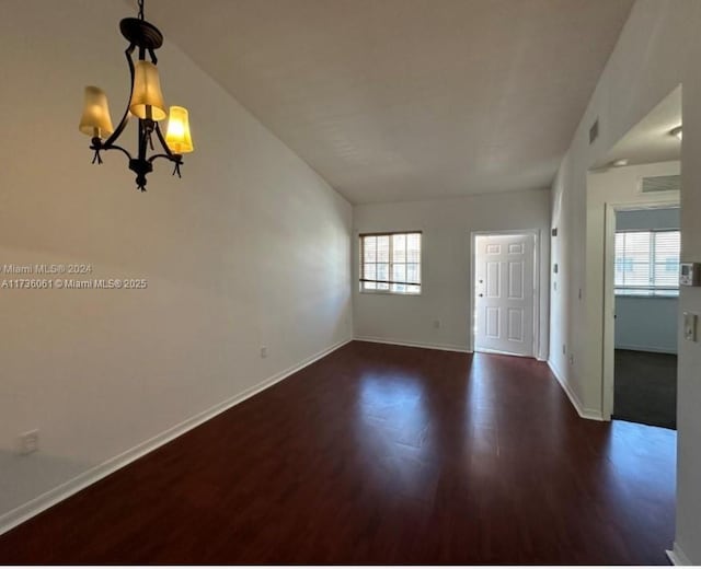 interior space featuring lofted ceiling, dark hardwood / wood-style flooring, and a chandelier