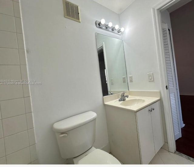 bathroom with vanity, tile patterned flooring, and toilet