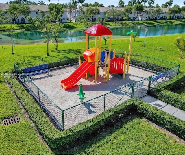 view of playground featuring a yard and a water view