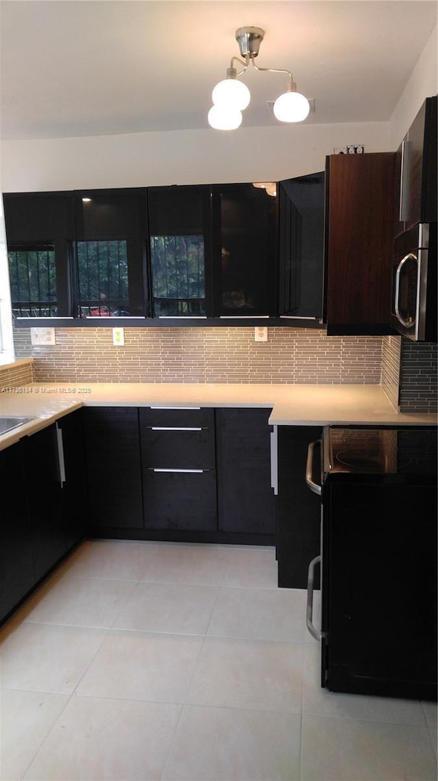 kitchen featuring tasteful backsplash, light tile patterned flooring, and range