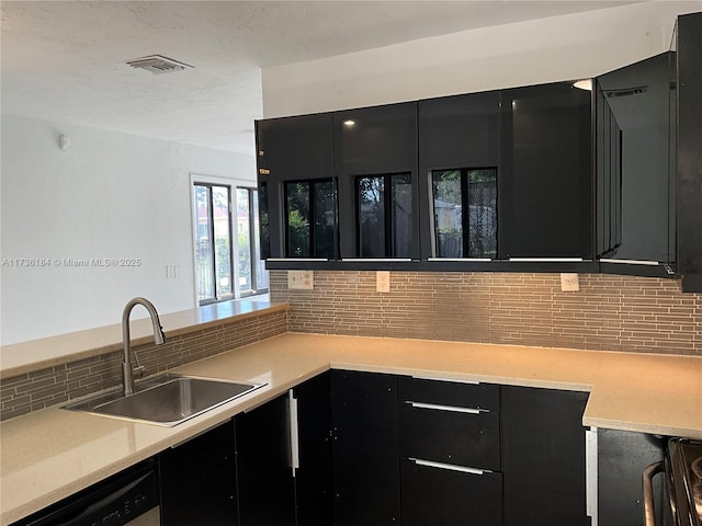 kitchen with tasteful backsplash, dishwasher, and sink