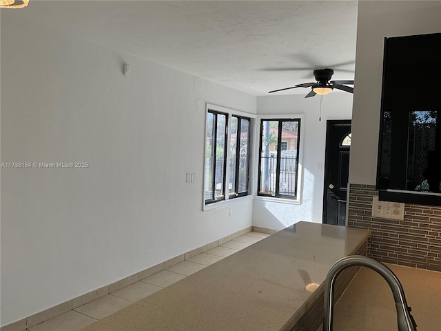 interior space with ceiling fan, sink, and light tile patterned floors