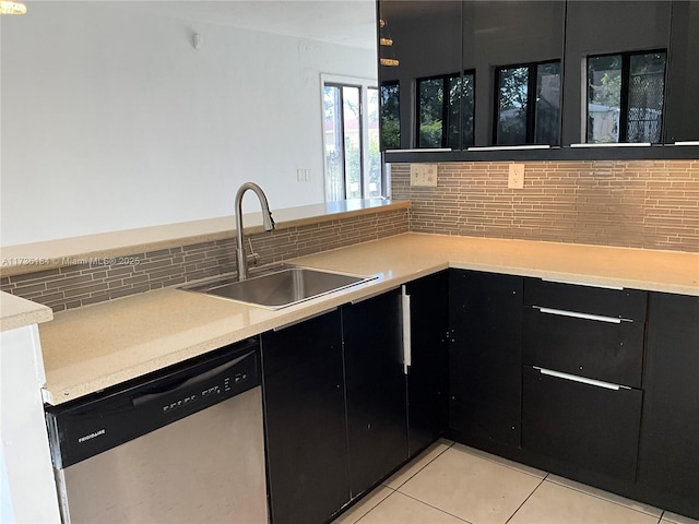 kitchen featuring dishwasher, sink, backsplash, light tile patterned floors, and kitchen peninsula