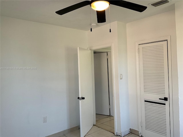 unfurnished bedroom with light tile patterned floors and ceiling fan