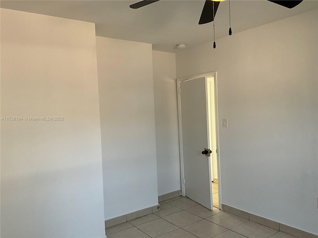 tiled empty room featuring ceiling fan