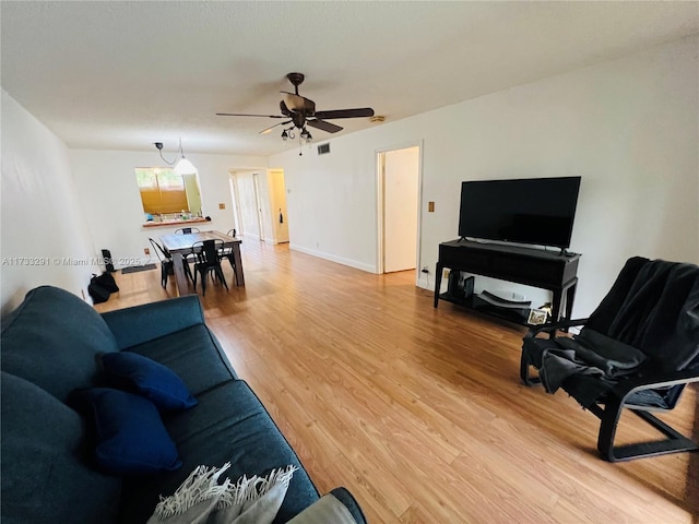 living room with wood-type flooring and ceiling fan