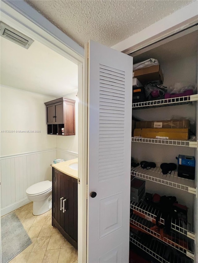 bathroom with vanity, tile patterned floors, a textured ceiling, and toilet