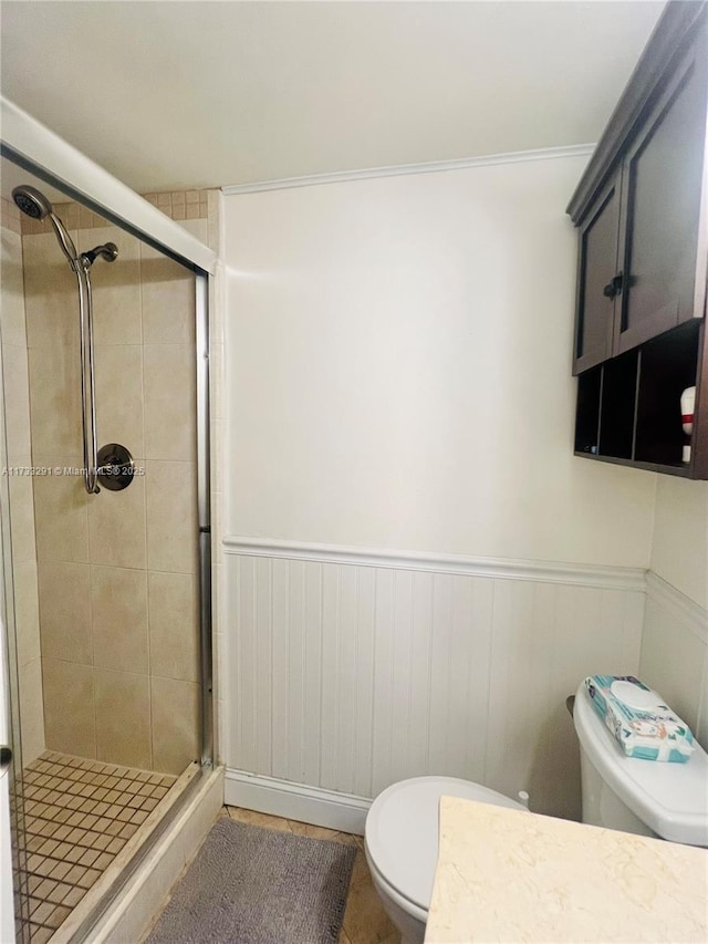 bathroom featuring toilet and a shower with shower door