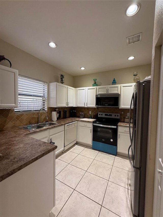 kitchen with white cabinetry, appliances with stainless steel finishes, sink, and light tile patterned floors