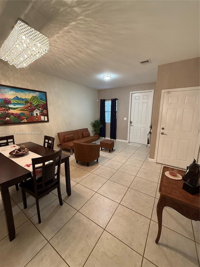 tiled living room featuring a chandelier and a textured ceiling