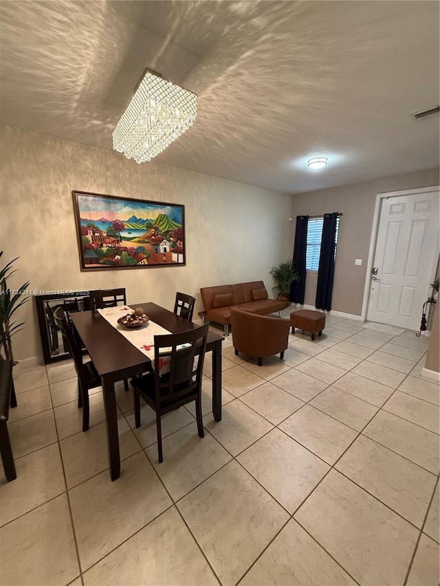 tiled dining room featuring an inviting chandelier and a textured ceiling