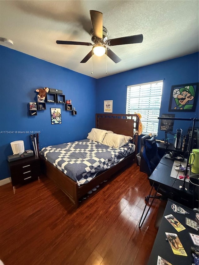 bedroom with ceiling fan, dark hardwood / wood-style floors, and a textured ceiling