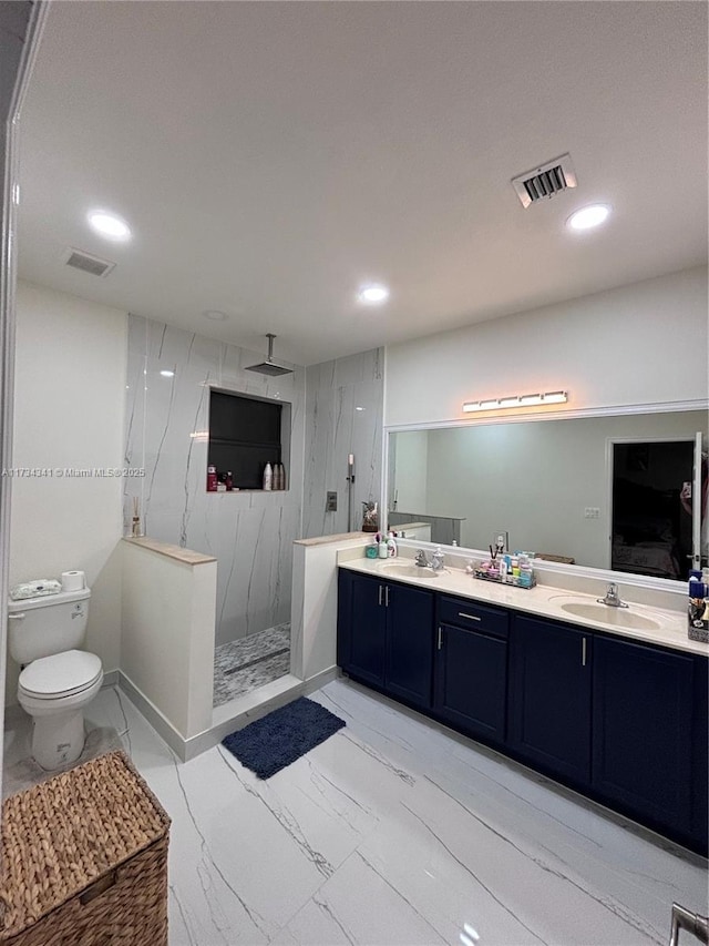 bathroom with vanity, toilet, and a tile shower