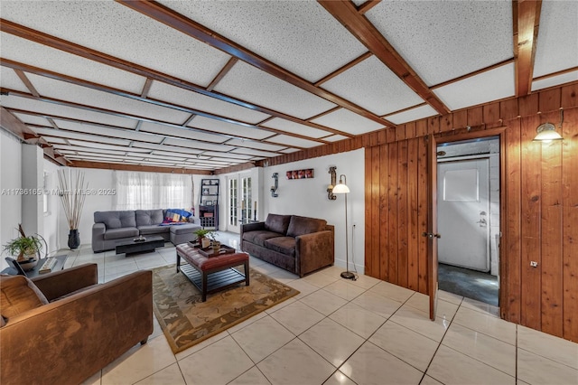 living room featuring light tile patterned floors and wood walls