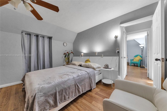 bedroom with vaulted ceiling, hardwood / wood-style floors, and ceiling fan