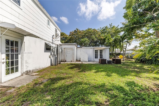 view of yard with central AC unit and french doors