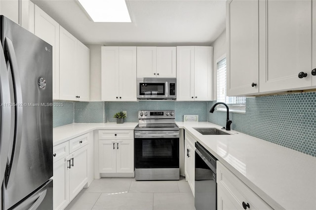 kitchen with sink, decorative backsplash, stainless steel appliances, and white cabinets