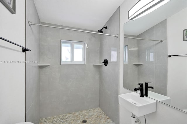 bathroom featuring sink and a tile shower