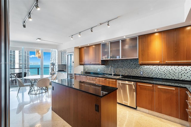 kitchen with sink, dishwasher, backsplash, hanging light fixtures, and a water view