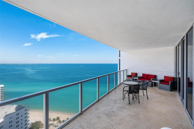 balcony with a water view, a beach view, and outdoor lounge area