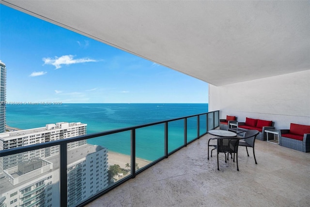 balcony featuring a water view, outdoor lounge area, and a beach view