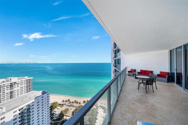 balcony with a water view and a view of the beach